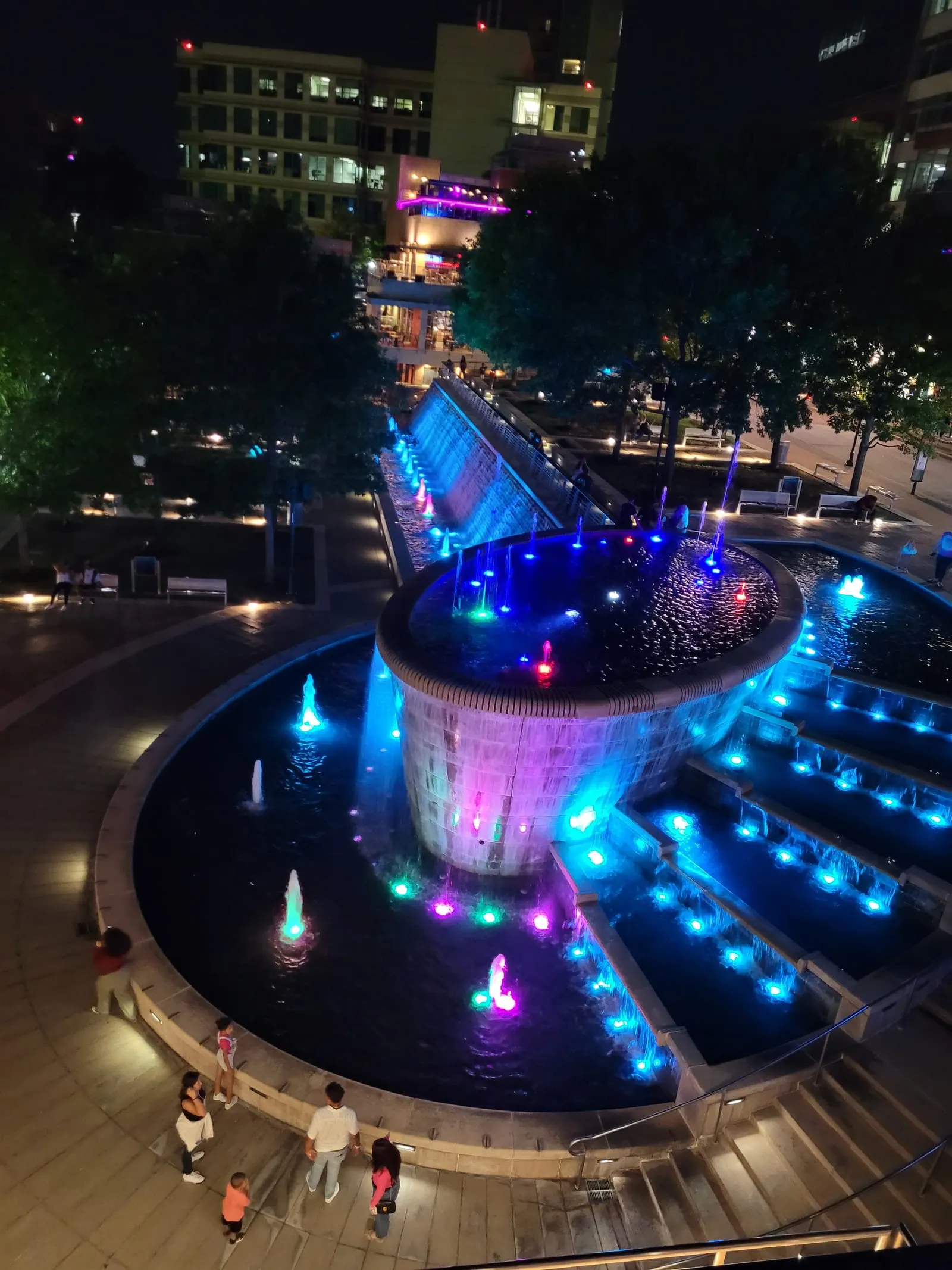 Waterway Square fountain lit in blue and purple at night in The Woodlands, TX